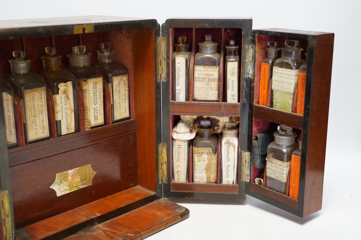 A late Victorian mahogany apothecary chest, containing a number of labelled glass bottles with preparations by James Woolley Sons and Co, Pharmaceutical Chemists, 28.5cm high, 25.5cm wide, 21cm deep. Condition - poor to